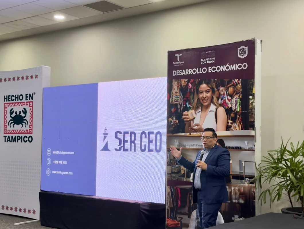 Alan participa con un micrófono en un espacio de encuentro empresarial.